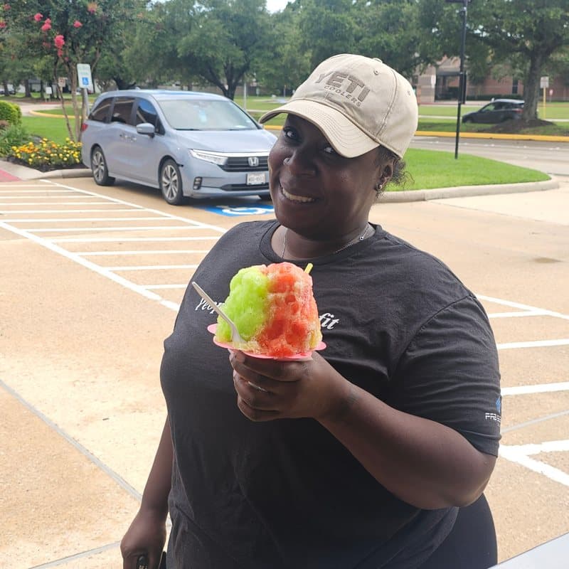 Happy customer holding two colorful shaved ices